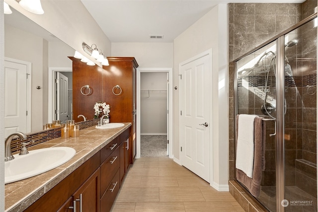 bathroom featuring an enclosed shower and vanity