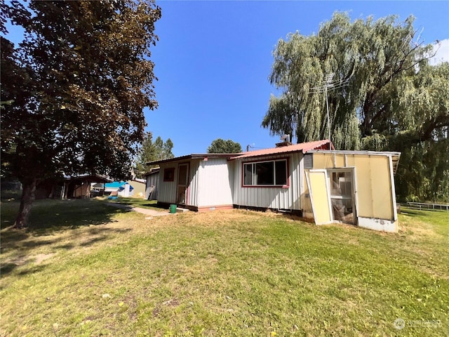 back of house with a lawn