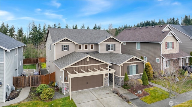 craftsman-style house featuring roof with shingles, board and batten siding, fence, stone siding, and driveway