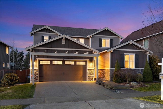 craftsman inspired home featuring driveway, a shingled roof, board and batten siding, and stone siding