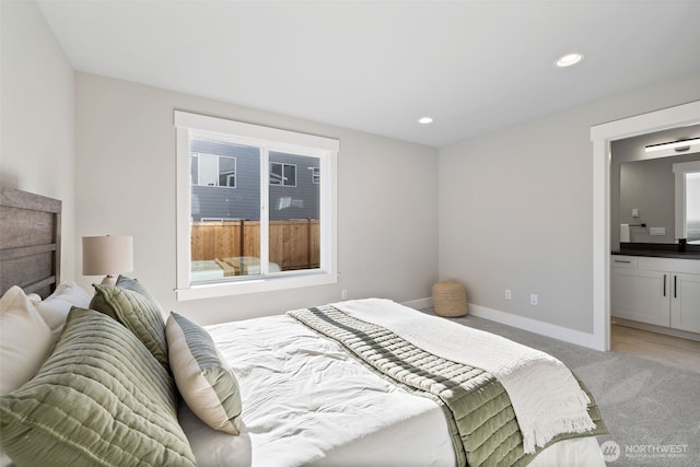 bedroom featuring connected bathroom, carpet floors, and sink