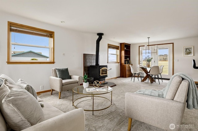 living room featuring light carpet, a wood stove, and baseboards