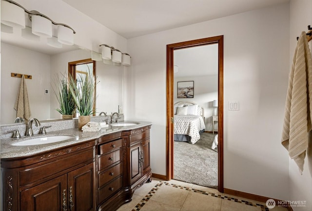 full bathroom featuring a sink, double vanity, connected bathroom, and baseboards