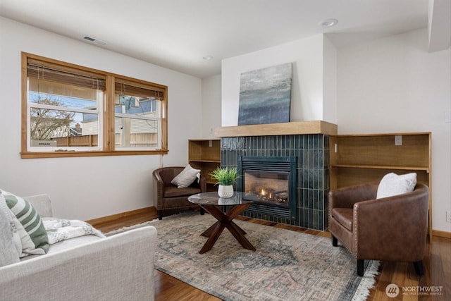 sitting room with recessed lighting, a fireplace, baseboards, and wood finished floors