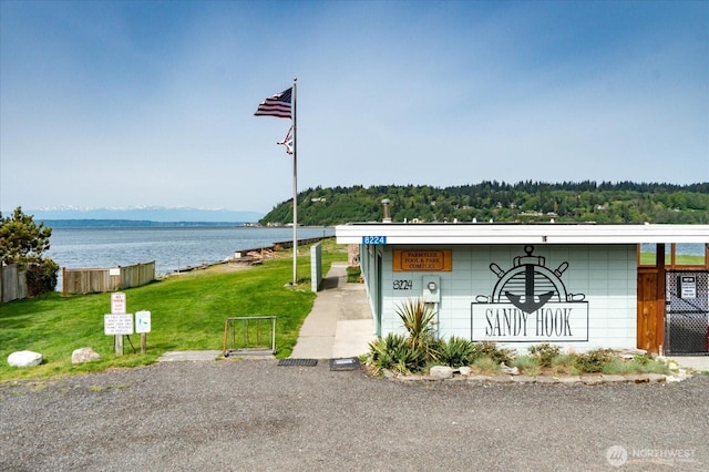 view of front of property featuring a front lawn and a water view