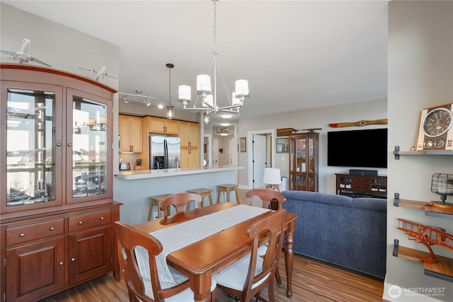 dining space with light wood-type flooring and a chandelier