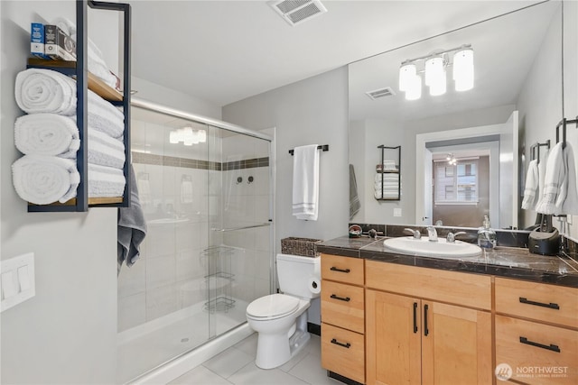 bathroom with an enclosed shower, vanity, tile patterned flooring, and toilet