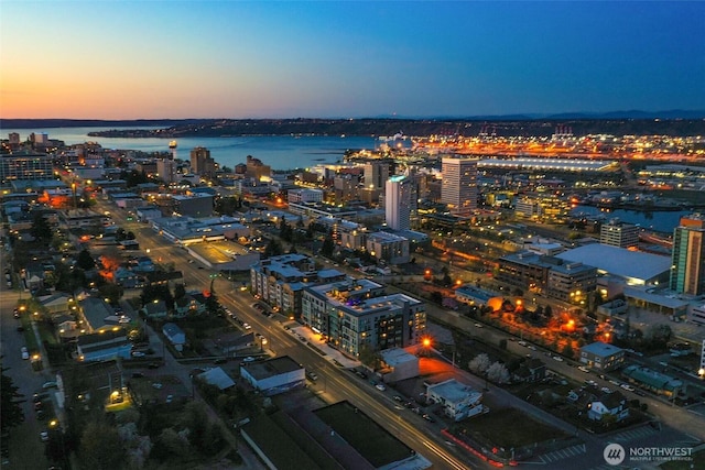 aerial view at dusk featuring a water view