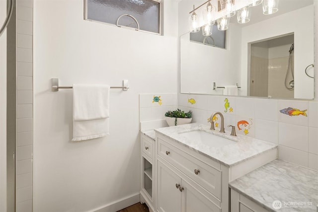 bathroom featuring vanity, backsplash, and walk in shower