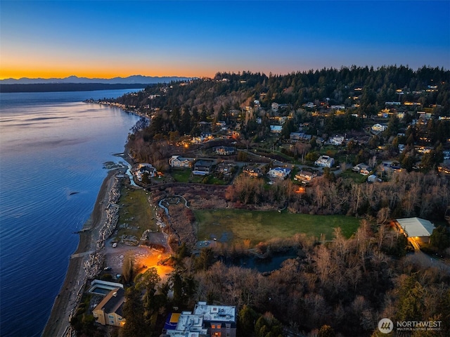 aerial view at dusk featuring a water and mountain view