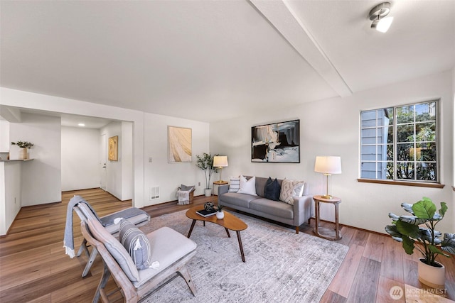 living room with beamed ceiling and wood-type flooring