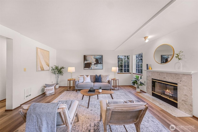 living room featuring wood-type flooring and a high end fireplace