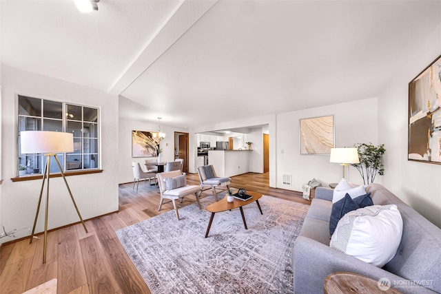 living room with wood-type flooring and a notable chandelier