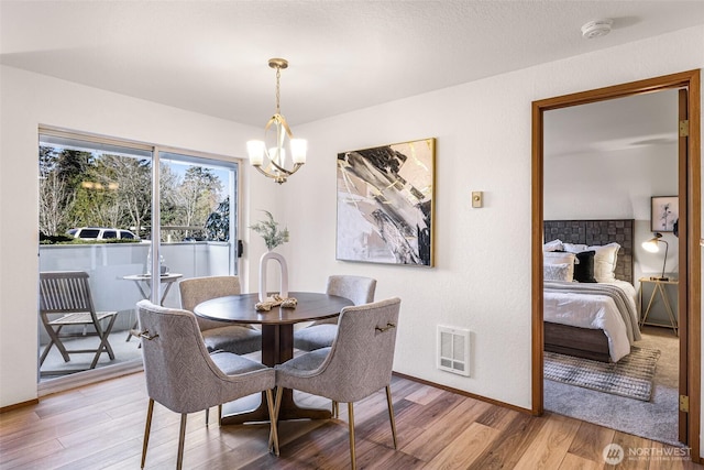 dining space with a notable chandelier and wood-type flooring