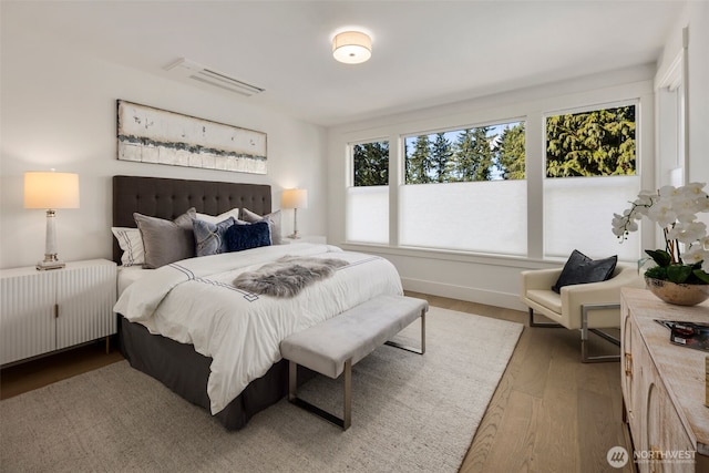 bedroom featuring baseboards, radiator heating unit, and wood finished floors