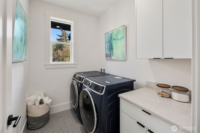 clothes washing area featuring washing machine and dryer, tile patterned flooring, cabinet space, and baseboards