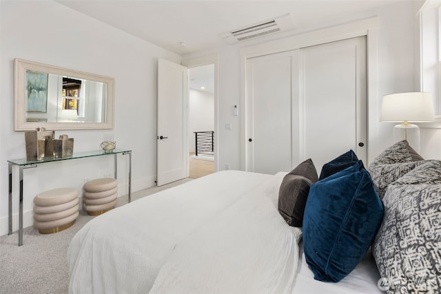 carpeted bedroom with a closet, visible vents, and baseboards