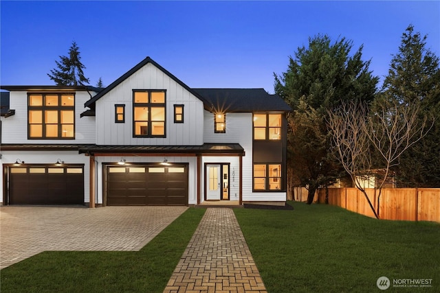 modern farmhouse style home featuring decorative driveway, an attached garage, board and batten siding, fence, and a front lawn