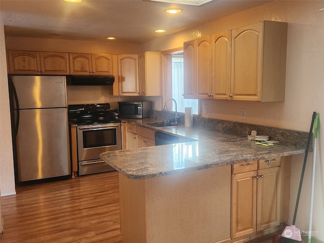 kitchen featuring sink, wood-type flooring, light brown cabinets, kitchen peninsula, and stainless steel appliances