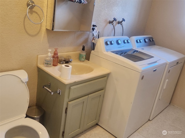 clothes washing area with washing machine and dryer and sink