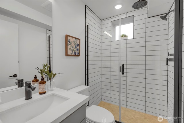 bathroom featuring toilet, vanity, and walk in shower