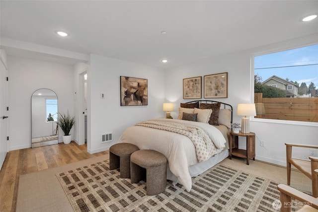 bedroom with multiple windows and light hardwood / wood-style floors