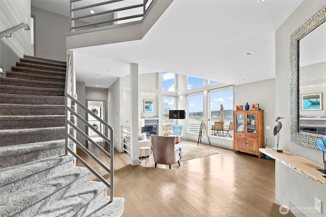 stairs featuring a glass covered fireplace and wood finished floors