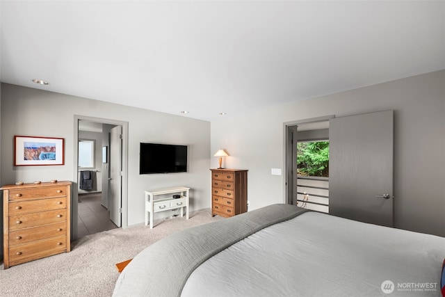 carpeted bedroom featuring multiple windows and connected bathroom