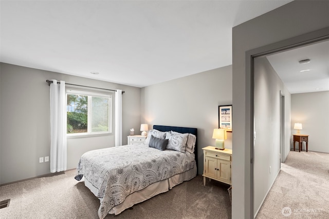 bedroom featuring visible vents and light colored carpet