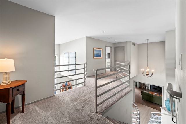 interior space featuring carpet floors, a fireplace, visible vents, and an inviting chandelier