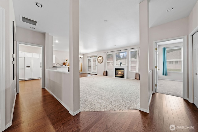 hallway with dark wood-style floors, visible vents, recessed lighting, and baseboards