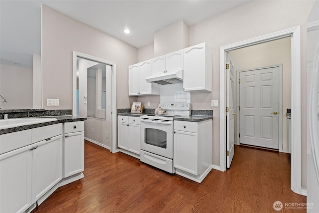 kitchen featuring under cabinet range hood, a sink, white electric range oven, white cabinets, and dark wood-style flooring