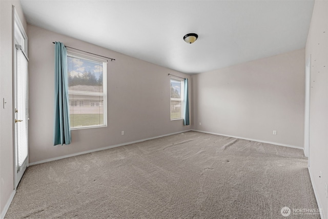 carpeted empty room with baseboards