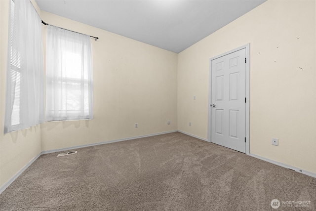 unfurnished room with visible vents, baseboards, and carpet flooring