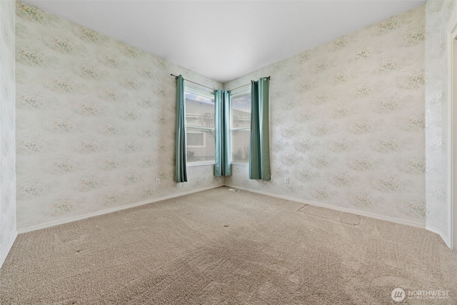 empty room featuring carpet flooring, wallpapered walls, and baseboards