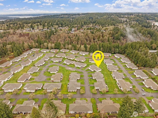 drone / aerial view featuring a residential view and a wooded view