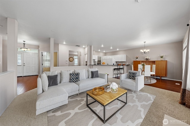 living room featuring light wood-style flooring, recessed lighting, visible vents, and a chandelier