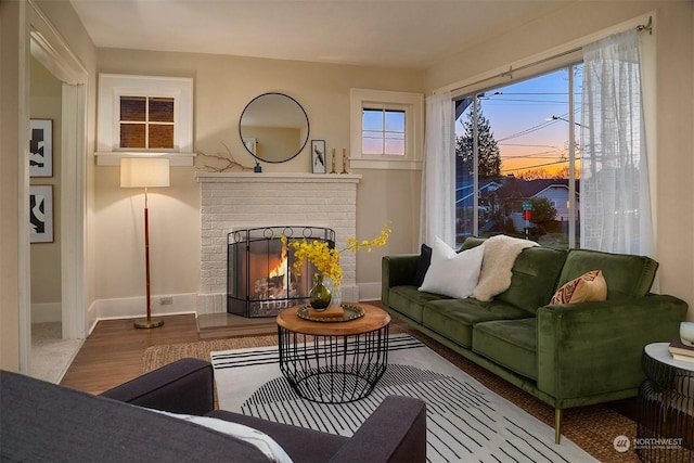 living area featuring a brick fireplace and hardwood / wood-style floors