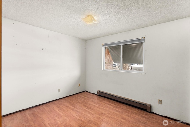 unfurnished room with light wood finished floors, a baseboard radiator, and a textured ceiling