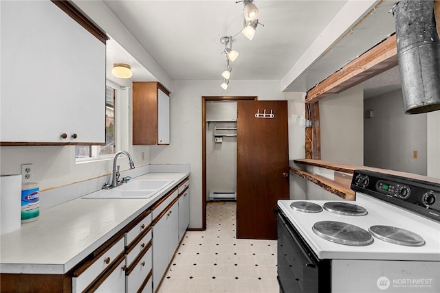 kitchen featuring electric stove, light floors, a baseboard radiator, light countertops, and a sink