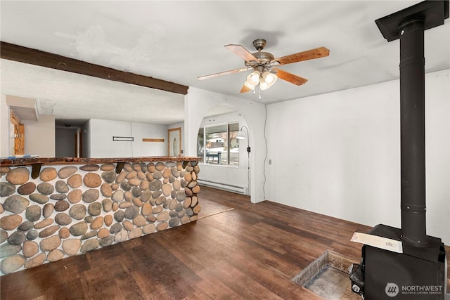 bar with ceiling fan, a baseboard heating unit, wood finished floors, beamed ceiling, and a wood stove