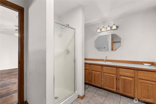 full bathroom featuring a shower stall, vanity, ceiling fan, and tile patterned floors