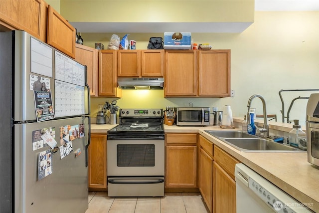 kitchen with stainless steel appliances, light countertops, a sink, and under cabinet range hood