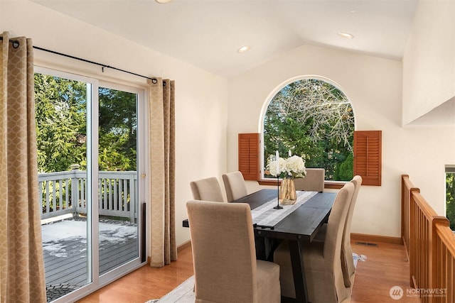 dining space featuring lofted ceiling and light hardwood / wood-style floors