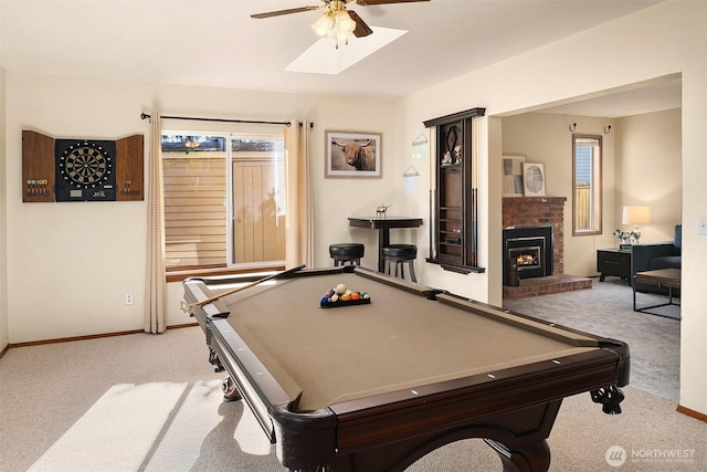 playroom with a wealth of natural light, a fireplace, light colored carpet, and ceiling fan