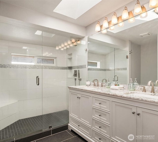 bathroom featuring a shower with door, vanity, and tile patterned floors