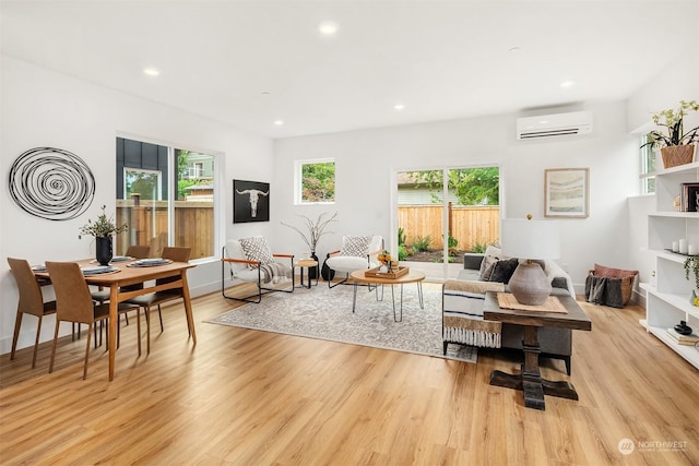 living room with a wall unit AC and light wood-type flooring