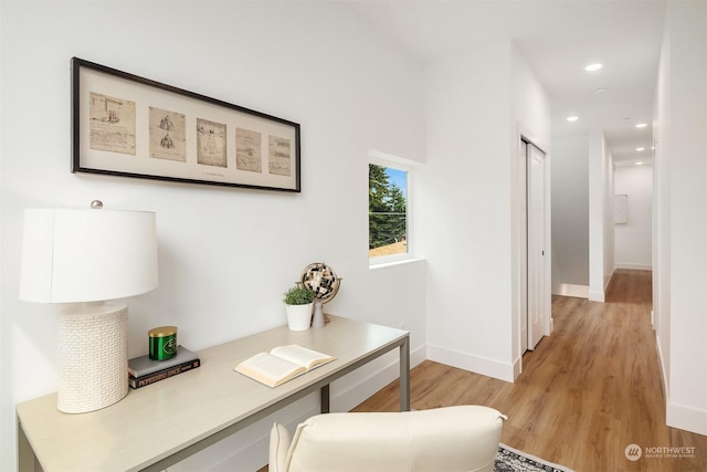 home office with light hardwood / wood-style flooring