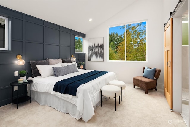 carpeted bedroom featuring vaulted ceiling and a barn door