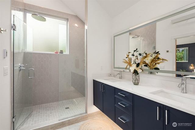 bathroom with tile patterned flooring, vanity, and walk in shower